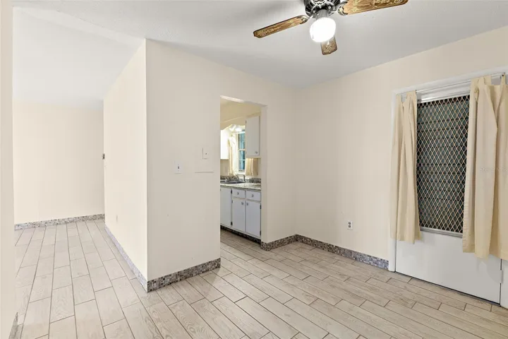 Dining area with tile flooring, ceiling fan, and open kitchen view
