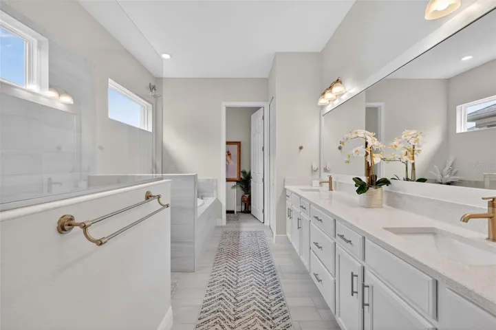 The Primary en-suite bathroom has a lipless walk-in shower, a soaker tub and dual vanities as well as a private water closet.