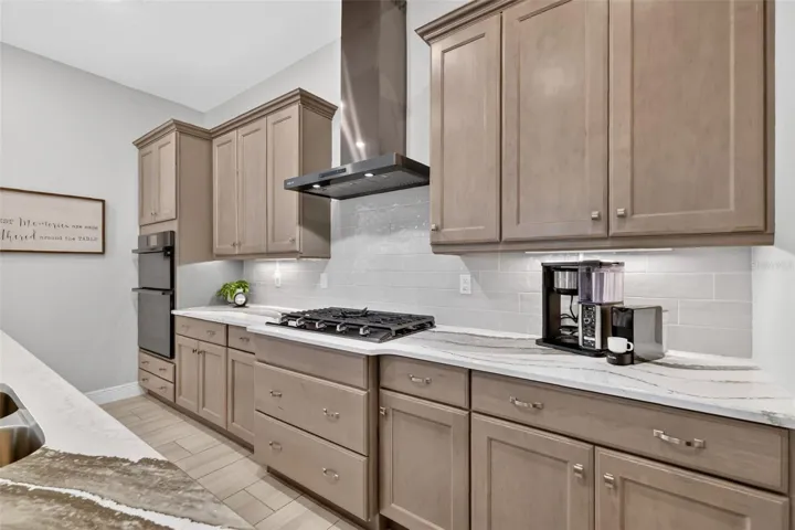 This kitchen is a chef's dream with plenty of preparation space, stainless steel appliances, 5 burner gas cooktop, in-wall oven and microwave, a large island and a walk-in pantry.