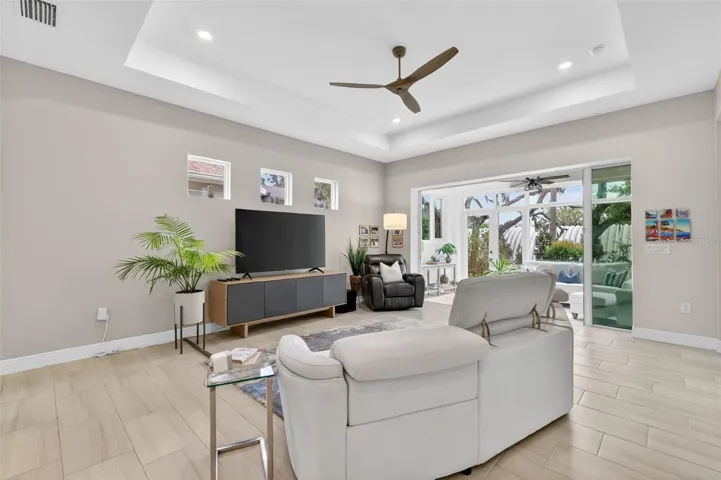 The trey ceiling and modern ceiling fan makes this living space inviting.