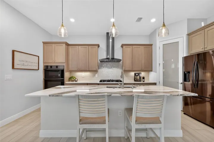 The stunning countertops, gas cooktop, walk-in pantry, combined with the functional island are just a few items that make this kitchen special.