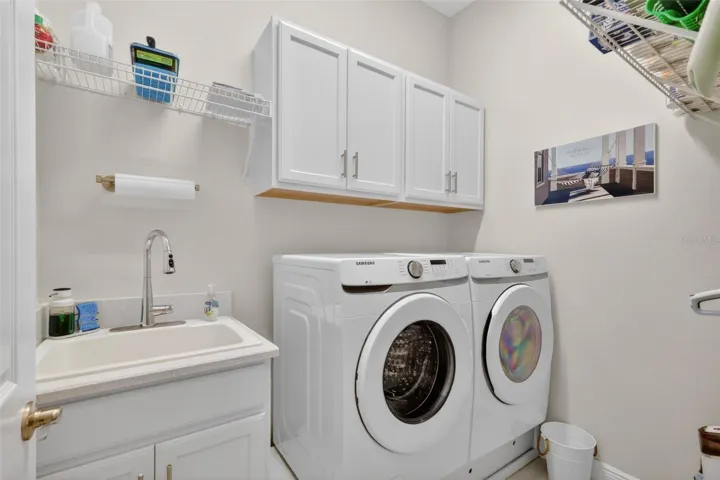 The laundry toom has a utility sink and a storage platform for the washer and dryer.