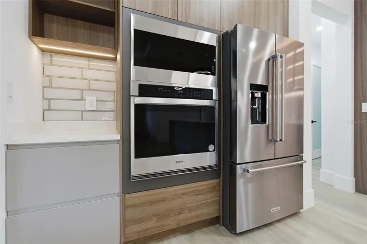 Kitchen with built-in oven and stainless steel appliances