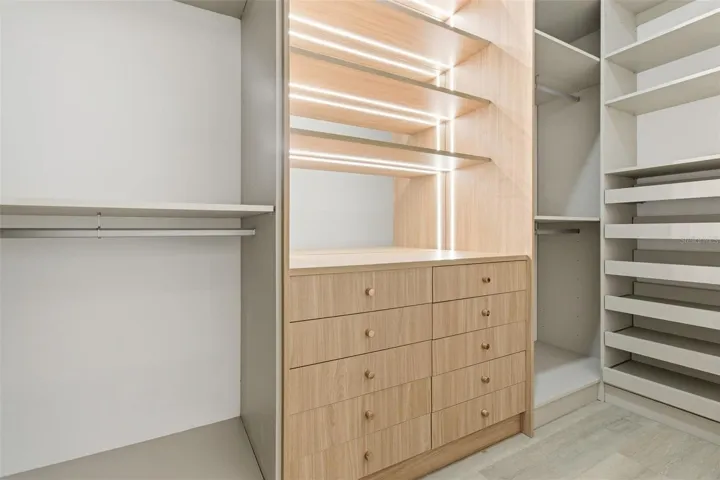 Walk-in closet with drawers, shelving & lighting
