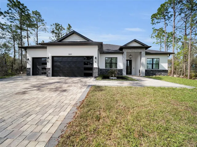 Front exterior with paver driveway and 3-car garage