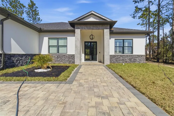 Front exterior with paver driveway and entry