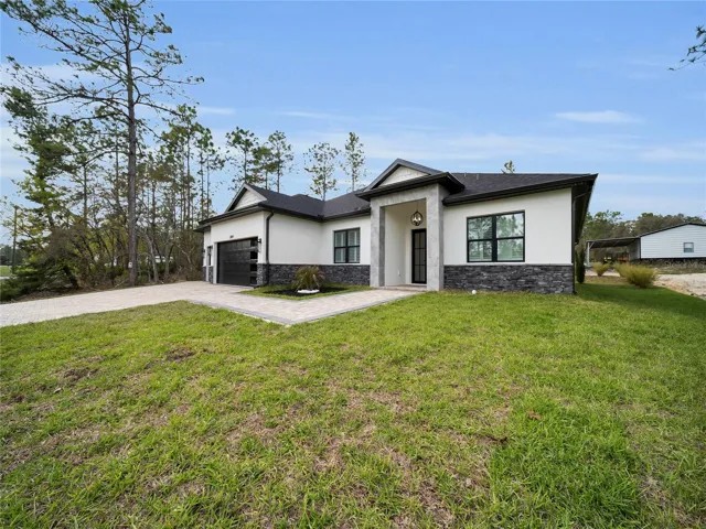 Front exterior with paver driveway and 3-car garage