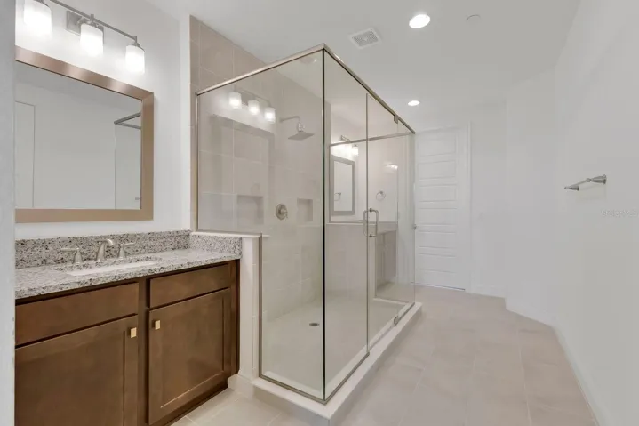 Primary Ensuite with large walk-in shower. Closet door leading into walk-in closet