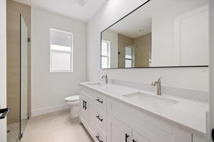 Master bath, double sink, Quartz counters, sleek tile surround