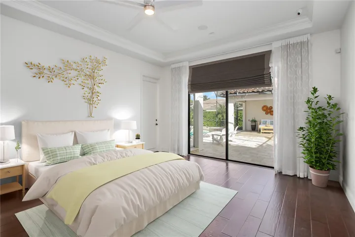 Master/Primary bedroom with sliders and door to covered deck and pool cabana
