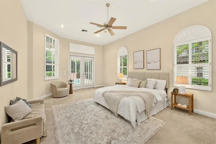 Primary bedroom with french doors to the pool area.