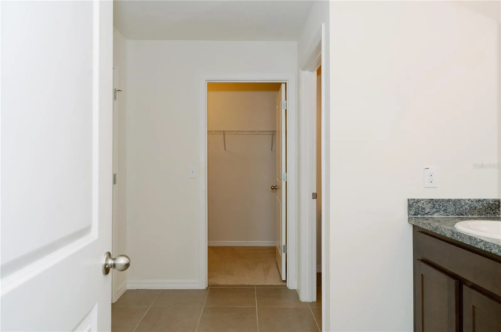 View from primary bathrrom door looking at walk-in closet door