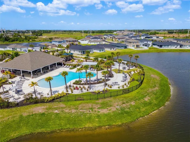 Welcome to Sawgrass Lakes! This stunning aerial view captures the resort-style community pool, manicured green spaces, and beautifully designed homesites that define one of Parrish's most desirable neighborhoods.