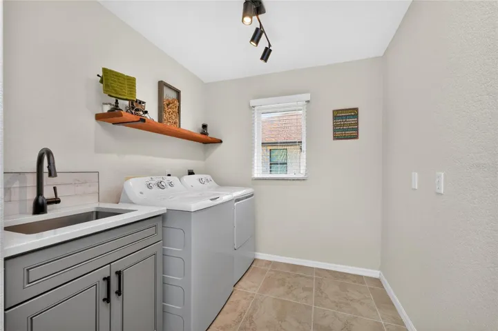 Inside laundry has a built in utility tub to match the kitchen cabinetry plus full size washer/dryer.