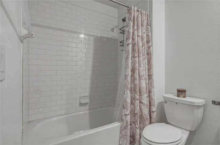 Full Second Bedroom Upstairs with Tile Surround, Square Undermount Sink and Granite Countertops.