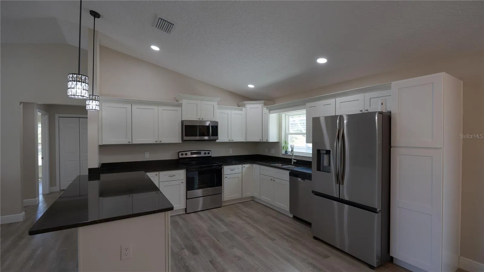 Kitchen with Breakfast Bar, Newer Refrigerator and Microwave.  Additional Pantry
