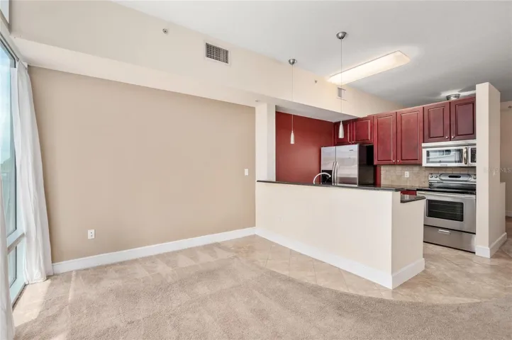Full kitchen with stainless steel like appliance and cherrywood cabinets.