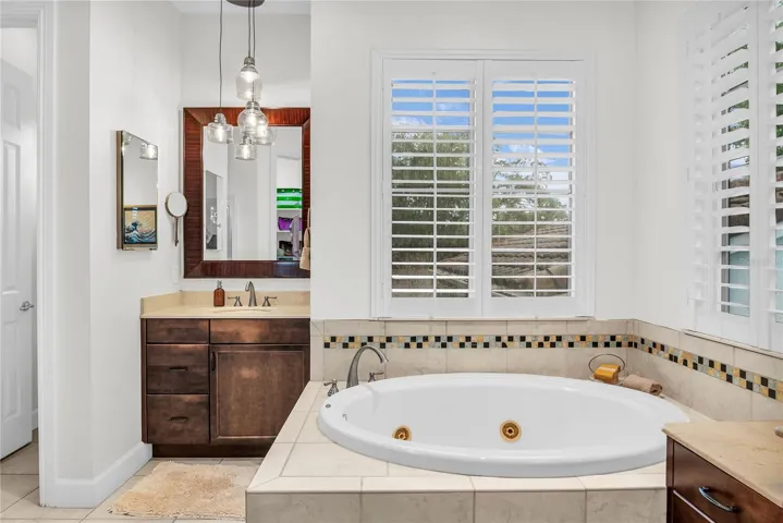 Primary bathroom with dual vanities, spa tub, toilet closet and walk-in shower