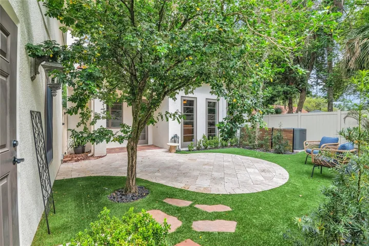 Backyard oasis- easy maintenance turf, Travertine pavers, covered porch and new white vinyl fence