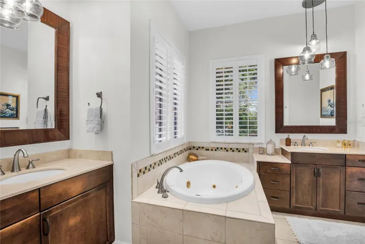 Primary bathroom with dual vanities, spa tub, toilet closet and walk-in shower