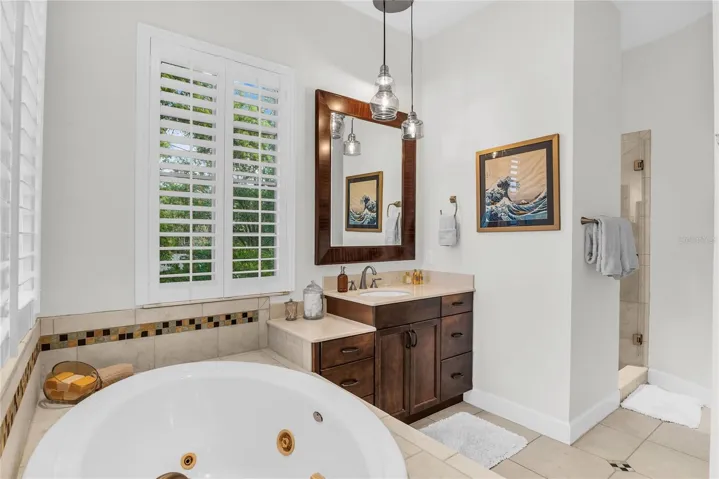 Primary bathroom with dual vanities, spa tub, toilet closet and walk-in shower