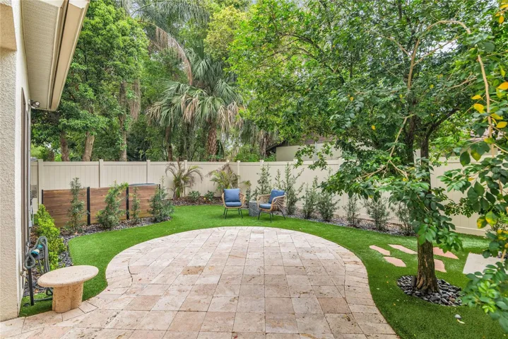 Backyard oasis- easy maintenance turf, Travertine pavers, covered porch and new white vinyl fence