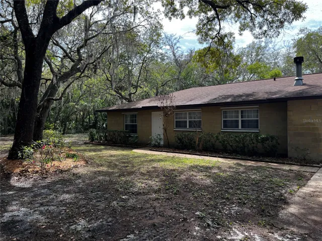 Gorgeous shade trees surround this solid Ocala Block home.