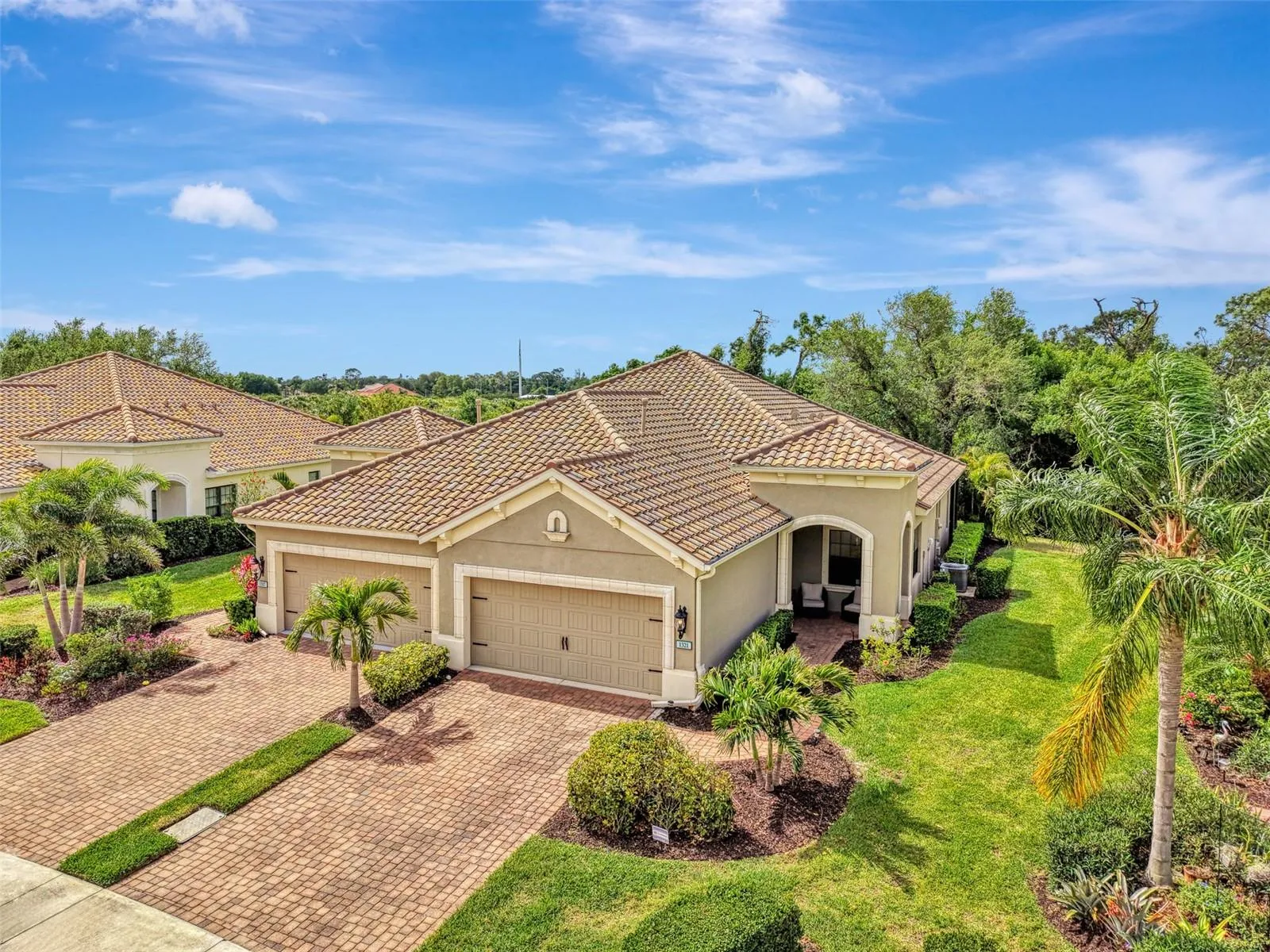 Paired villa in Boca Royale with paver driveway and tile roof. Tropical setting in North Englewood.