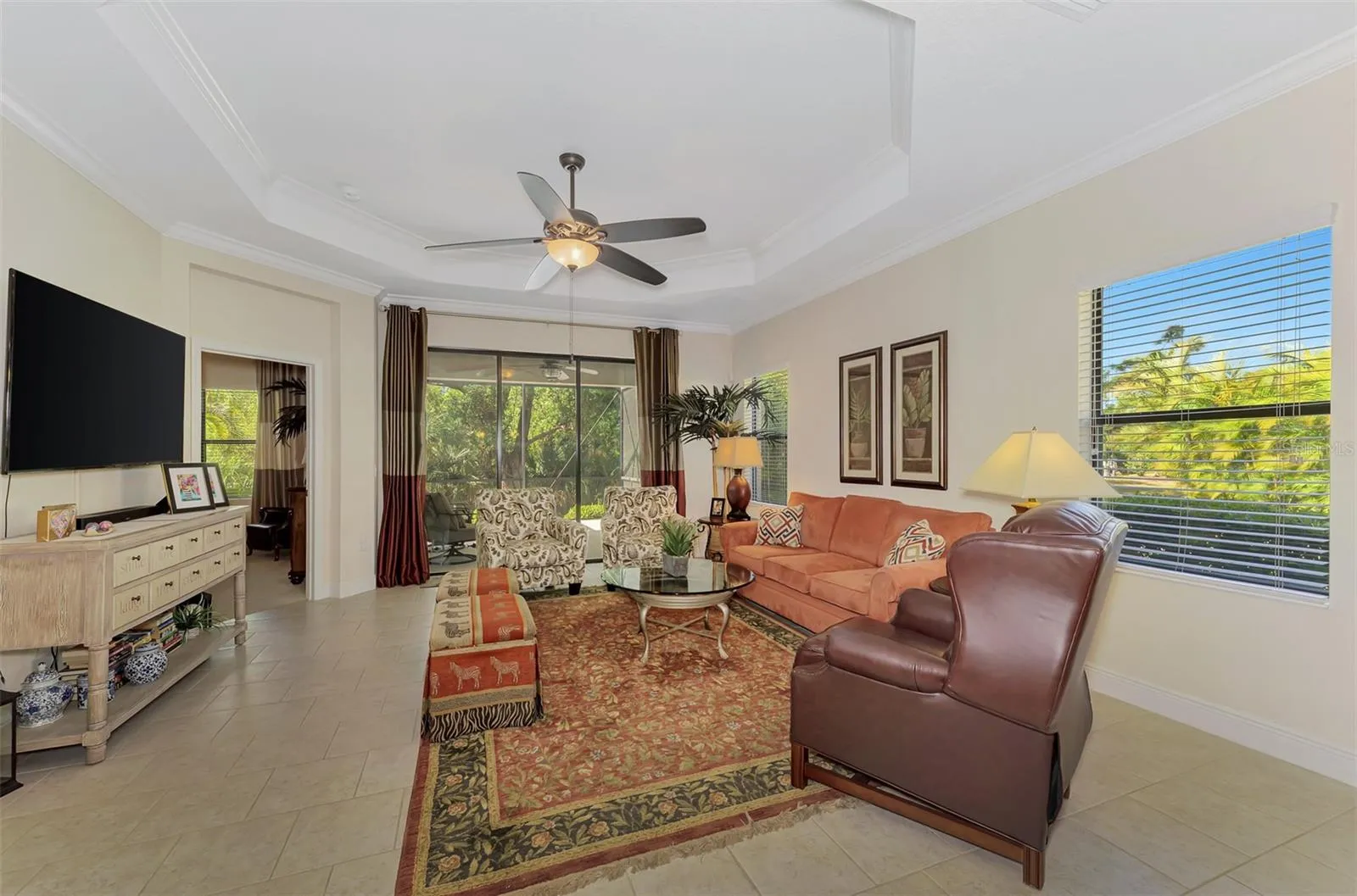 Living Room with Step-Ceiling and Crown Molding, Blinds, Sliders, Drapes, Ceiling fans, Screened lanai.