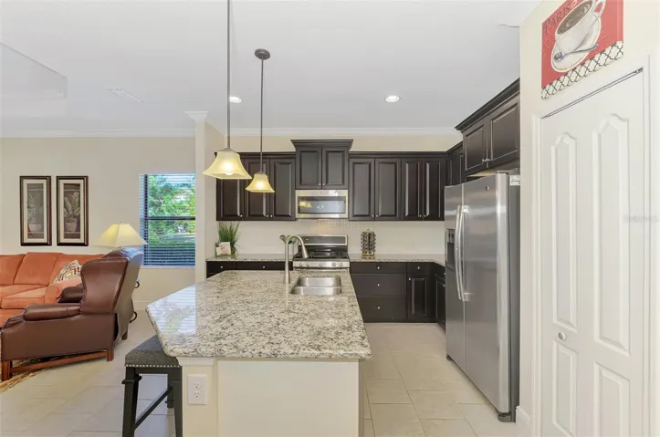 Crown molding, stainless appliances and pantry with eat-in kitchen island.