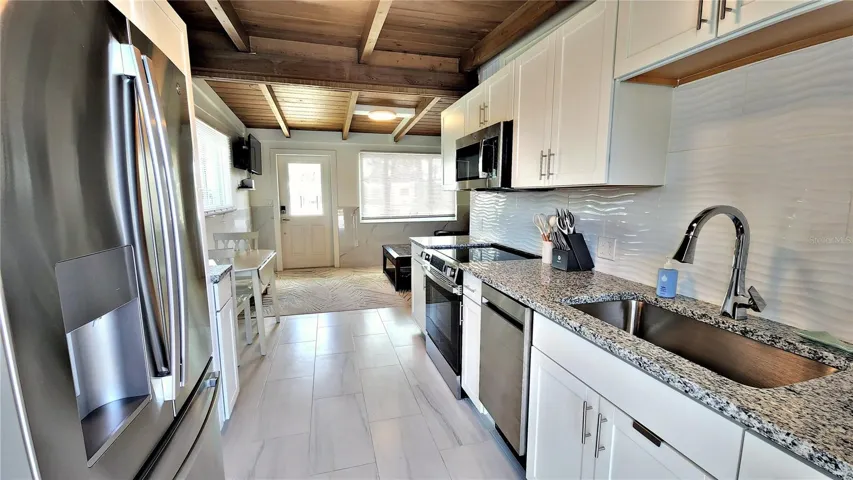 STEP INTO THE KITCHEN FROM THE DRIVEWAY. DOOR AHEAD TO THE POOL.