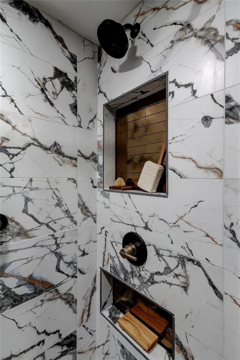 Owner's Retreat Walk in Shower.. Striking Style, Black/Gold Delta Fixtures, Shimmering Gold Accent Tiles, Adorn 2 Large Niches .. Curated Storage Centric Design!
