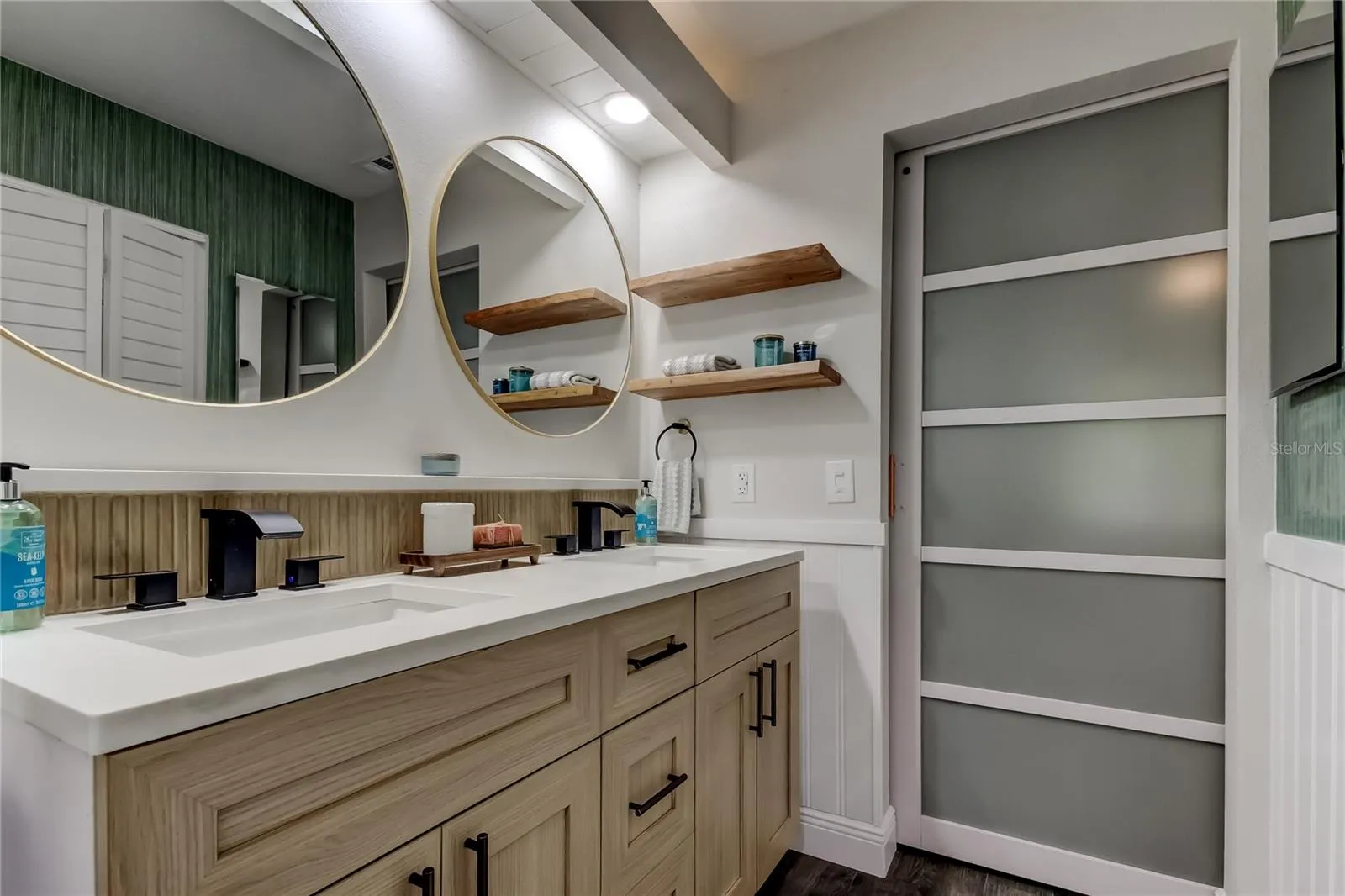 White Oak Dual Sink Vanity w/Stone Counter + Stylish Stone Shelf Atop Cohesive Accent Tile, Black LED Color Changing Faucets.. Imagine Getting Ready in this Luxury Ensuite Each Morning! (11.3x7.4)