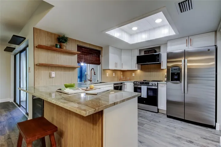 DESIGNER KITCHEN (10.11x9.4).. Mini Fridge, Breakfast Bar, Shiplap Detail on Ceiling, Walk-inPantry, & High Quality Stainless Steel NEW Kitchen Appliances.