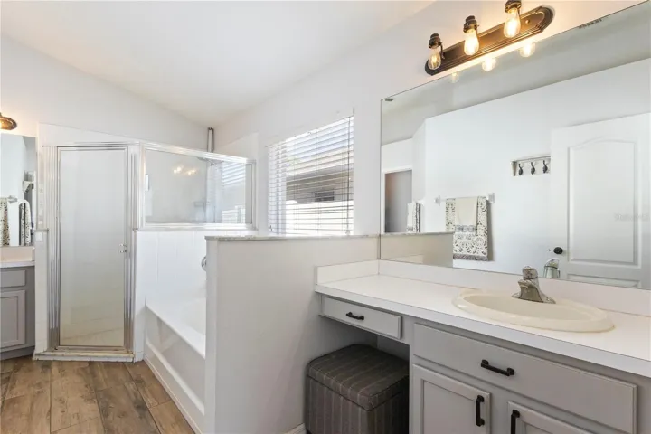 The light modern primary bathroom offers space for preparation or relaxtion with separate vanities!