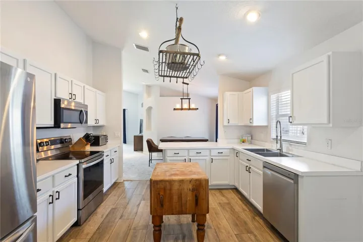 This kitchen is a cooks dream with the pot holder above the butcher block island!