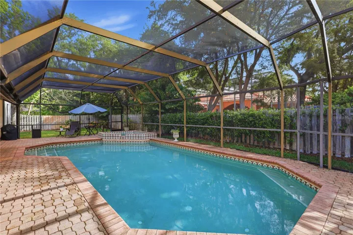 Screened pool and raised spa with expansive paver deck-perfect for relaxing or entertaining