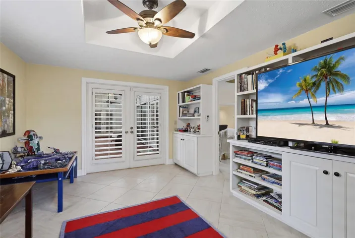 Separate den or home office with built-in shelving and French doors to the pool and lanai