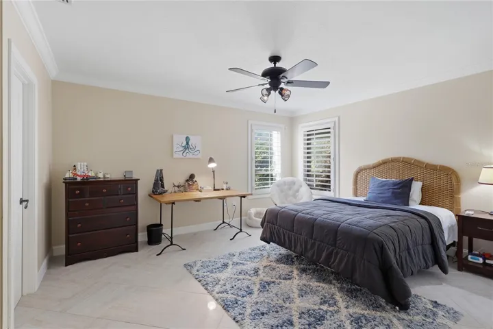Light-filled bedroom with plantation shutters and ceiling fan