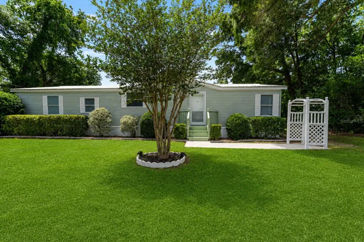 The front of the well-maintained home showcases its curb appeal with a neatly landscaped lawn, a welcoming porch, and an inviting entryway.