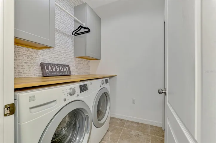 Charming laundry with Washer and Dryer included. Storage Cabinets. Dry bar.