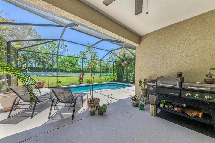 Covered lanai with views to screened pool and large fenced backyard.