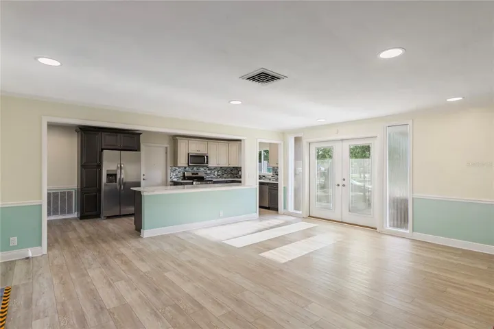 Light streams through the new front doors into a large open concept family room with all new flooring where friends and family gather.