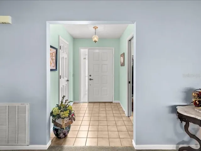 FOYER WITH TILE FLOOR, COAT CLOSET AND ACCESS TO THE DEN/OFFICE.