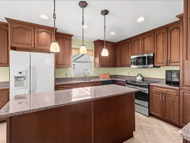 KITCHEN HAS BEEN UPDATED WITH TILE FLOOR, MODERN CABINTERY AND SOLID SURFACE COUNTERTOPS.