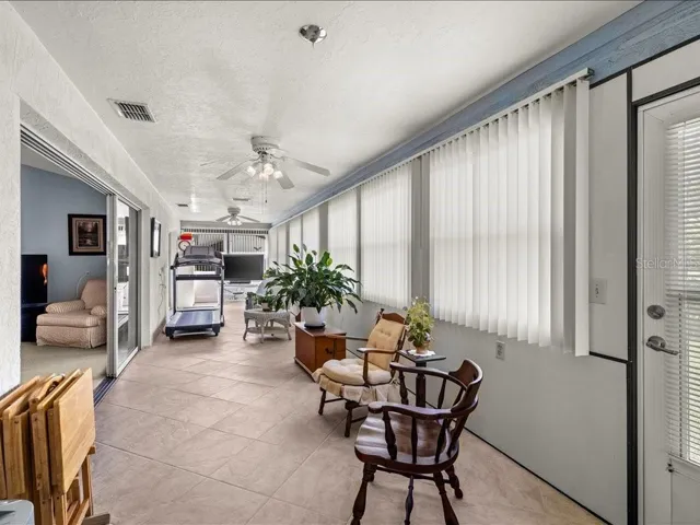 YEAR ROUND FLORIDA ROOM HAS A WALL OF WINDOWS AND IS ACCESSIBLE FROM THE KITCHEN, LIVING ROOM AND PRIMARY BEDROOM.