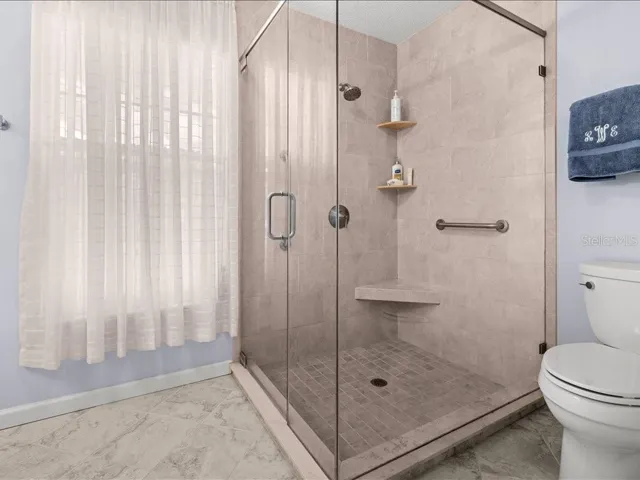 THE WALK-IN SHOWER HAS BEEN UPATED WITH TILE AND GLASS ENCLOSURE.