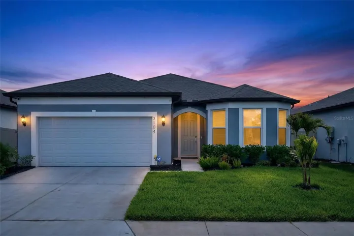 Beautiful twilight curb appeal with warm lighting, showcasing this well-maintained home with inviting entry and modern exterior design.