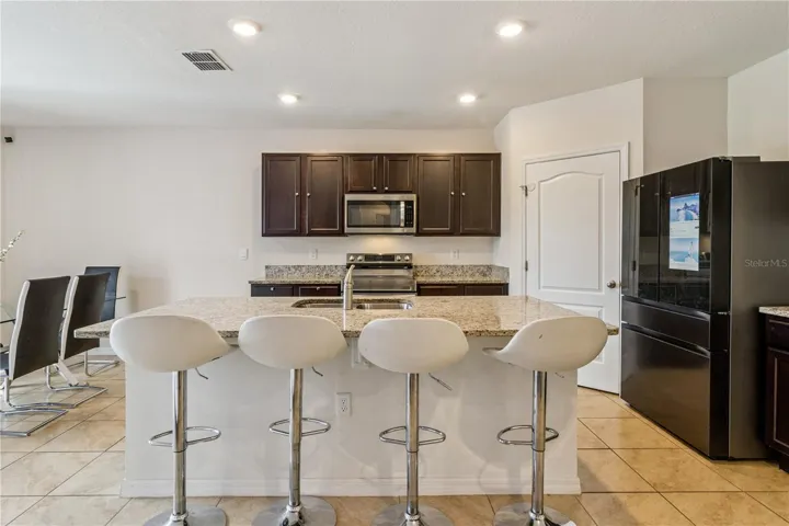 Kitchen with counter hight island and stainless appliances