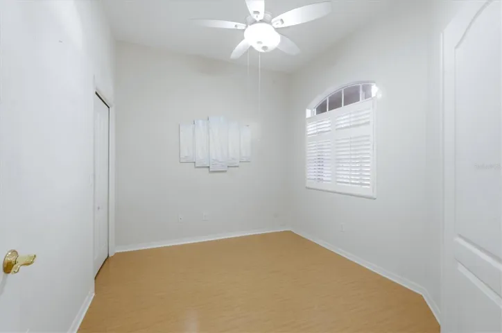 second bedroom with  plantation blinds and walkin closet